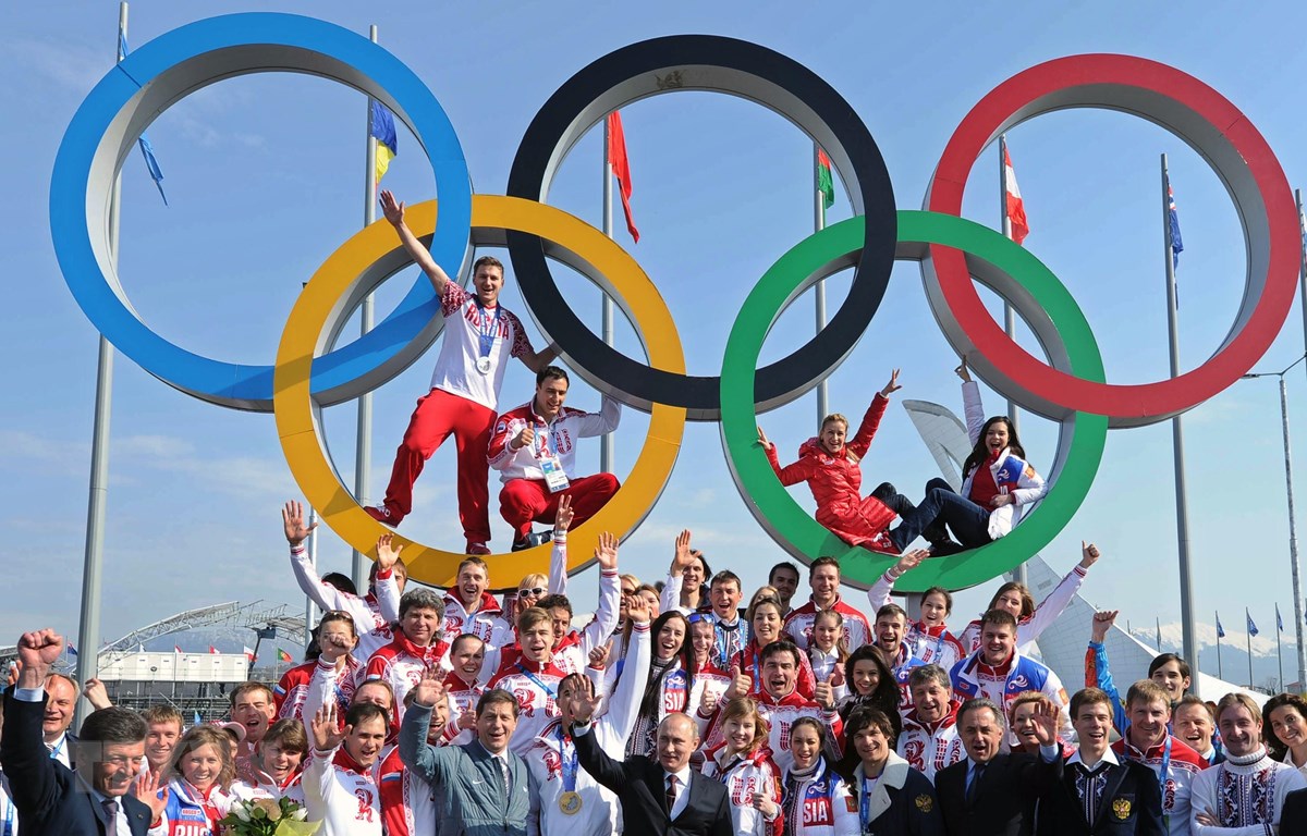 Tổng tống Nga Vladimir Putin (giữa) chụp ảnh chung với các vận động viên Nga tại Sochi ngày 24/2/2014. (Ảnh: AFP/TTXVN)